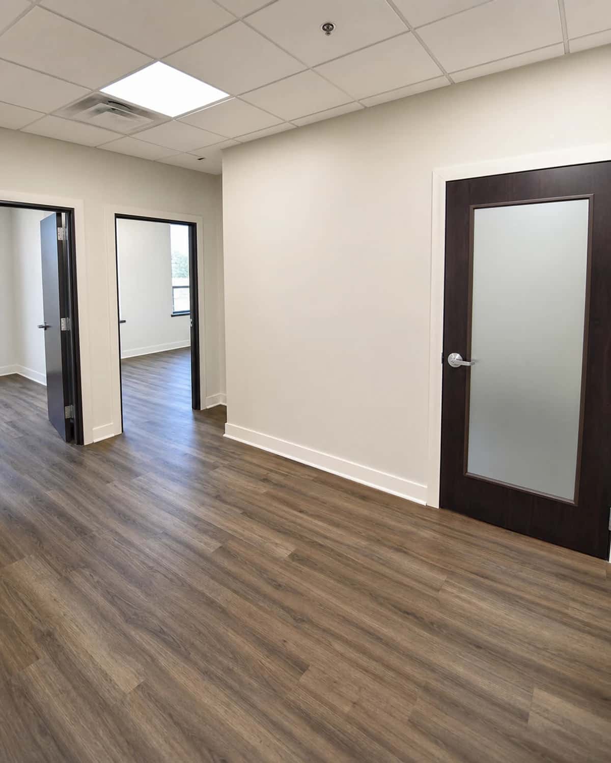 Refreshed tenant turnover suite with clean walls, durable flooring, trim, and lighting