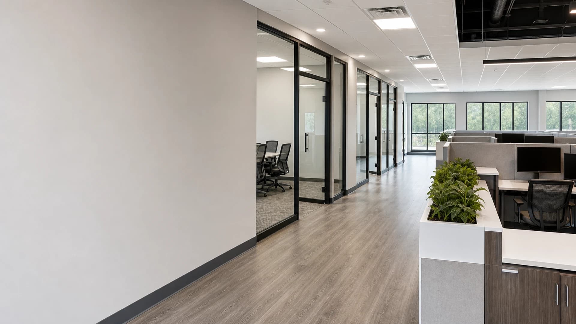 Professional office buildout with conference rooms, open work areas, glass partitions, lighting, and durable finishes.