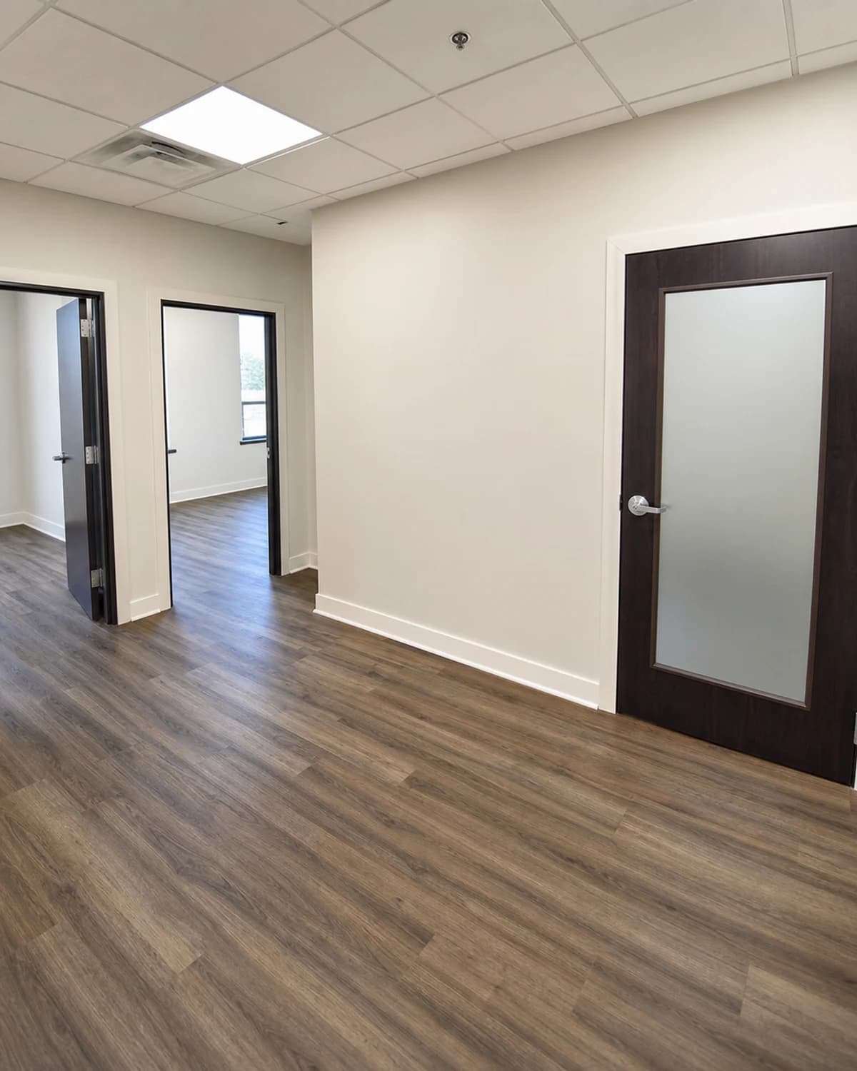 Refreshed tenant turnover suite with clean walls, durable flooring, trim, and lighting