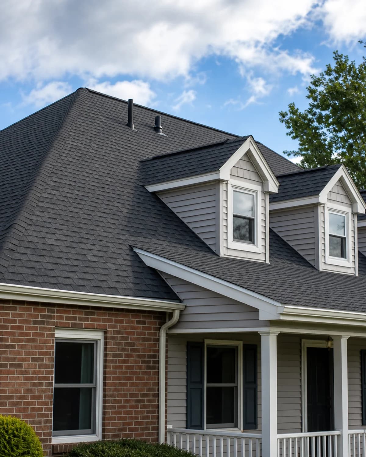 Finished asphalt shingle roofline with gutters, vents, and clean ridge details