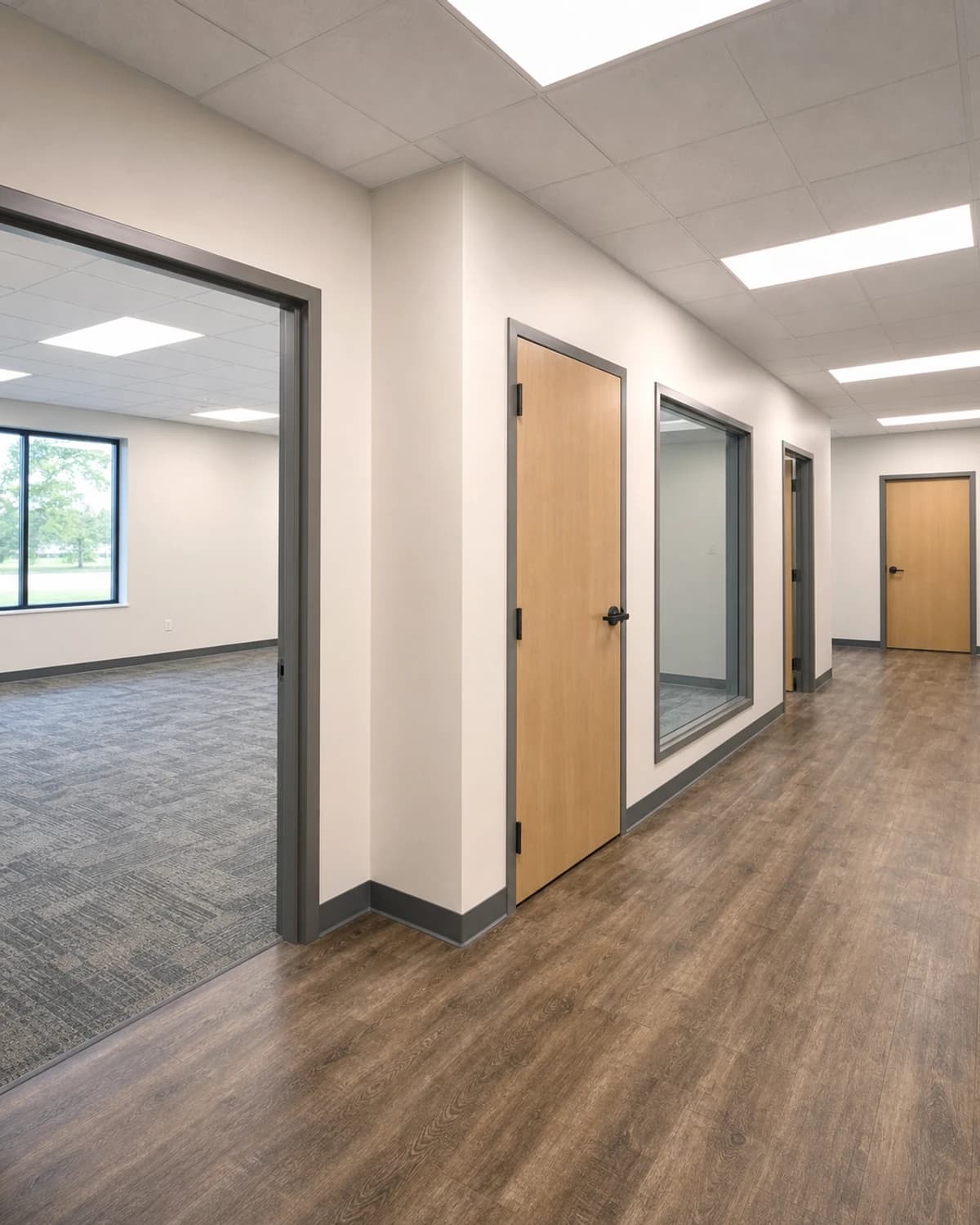Finished tenant suite with clean walls, durable flooring, lighting, ceiling grid, doors, and move-in-ready commercial finish