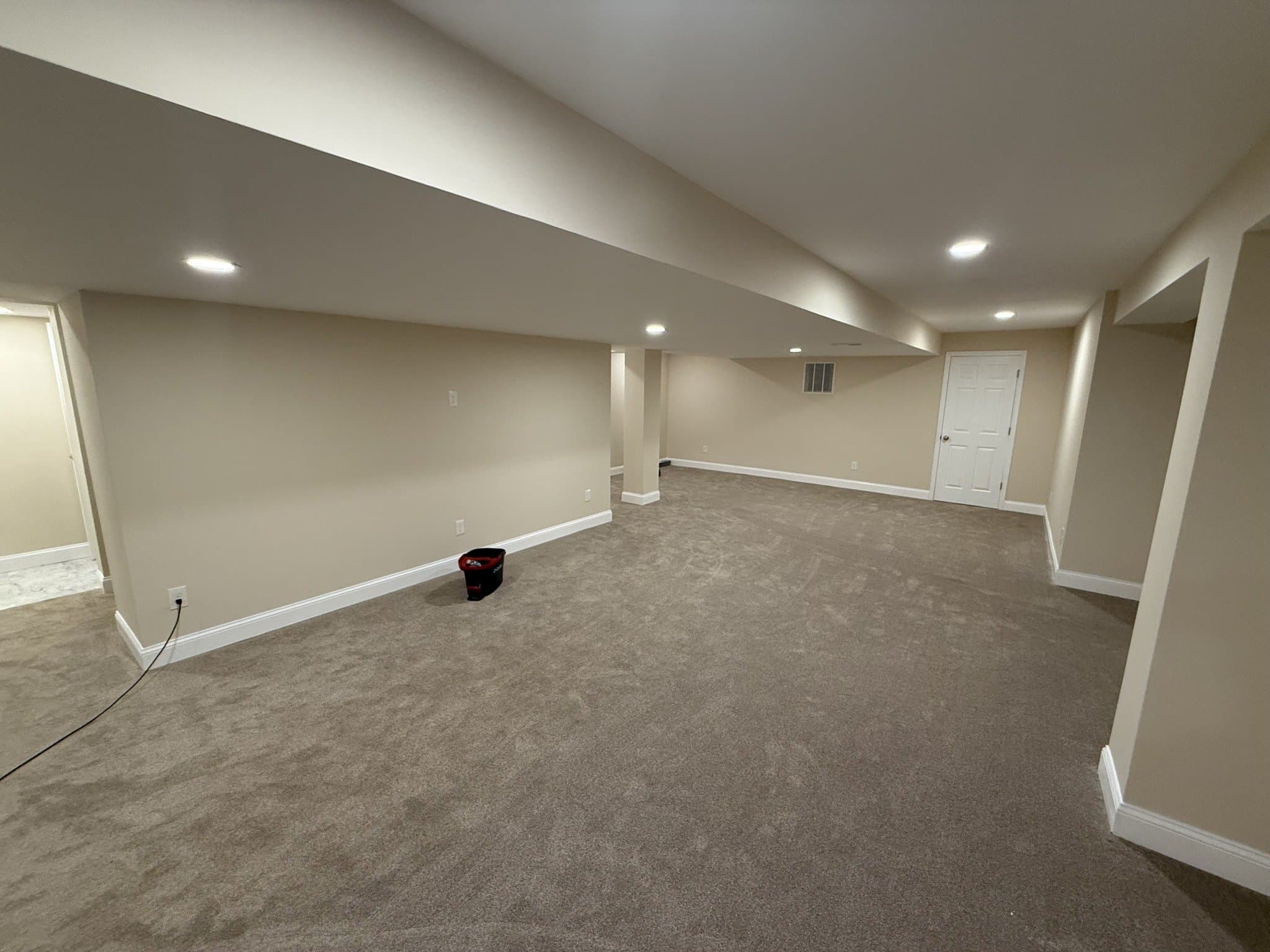 Finished basement living area with carpet, recessed lighting, painted walls, and white trim