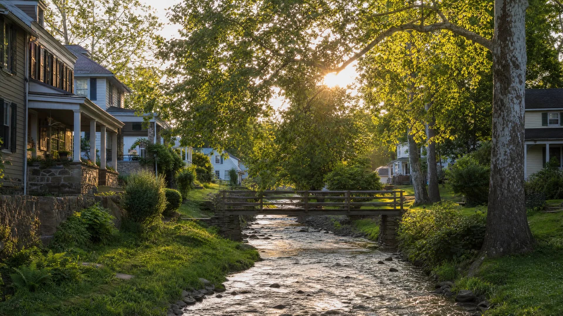 Creek-side small-town homes along a tree-shaded stream in Hellertown, PA, served by Conrad General Contracting.