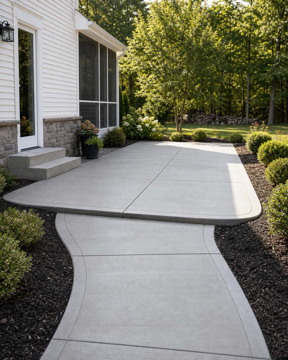 Completed concrete patio and walkway with durable finish, clean transitions, landscape borders, and contractor craftsmanship